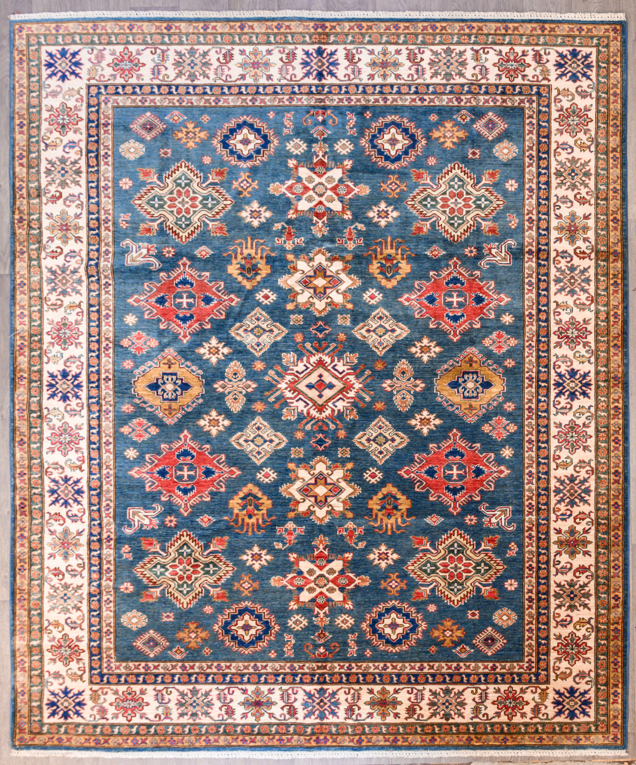 Authentic Handknotted Fine large Super Kazak Wool Rug 298cm x 253cm
Dramatic Aztec style Design Super Kazak rug with made from local vegetable plant dyes
Truly a one of a kind rug unmatched in design &amp; colour, large and lovely.

Woven Using Premium Quality Wool gives an Unrivalled Shine Off the Pile
Originating from the Caucaus Region, the Kazak Design is now Mastered by the Generational Weavers of North-Central Asia
