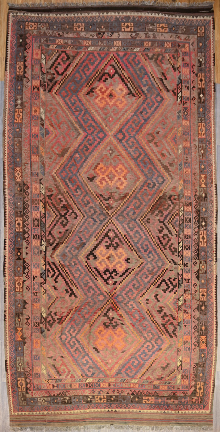 Authentic Handknotted XL Vintage c.1950's Persian Kilim 500cm x 256cm In harmonising colours of deep brown and pale orange, dark pink and pale indigo this unusual longer length rug is a true beauty.
The colour tones have aged gracefully over the decades and the wool has softened. Fringes are short and practical.Kilims are a light flatweave reversible rug used for over a millennium by the nomadic tribes of Central Asia. These portable rugs can also go with you on travels, picnics, camping trips or even beach
