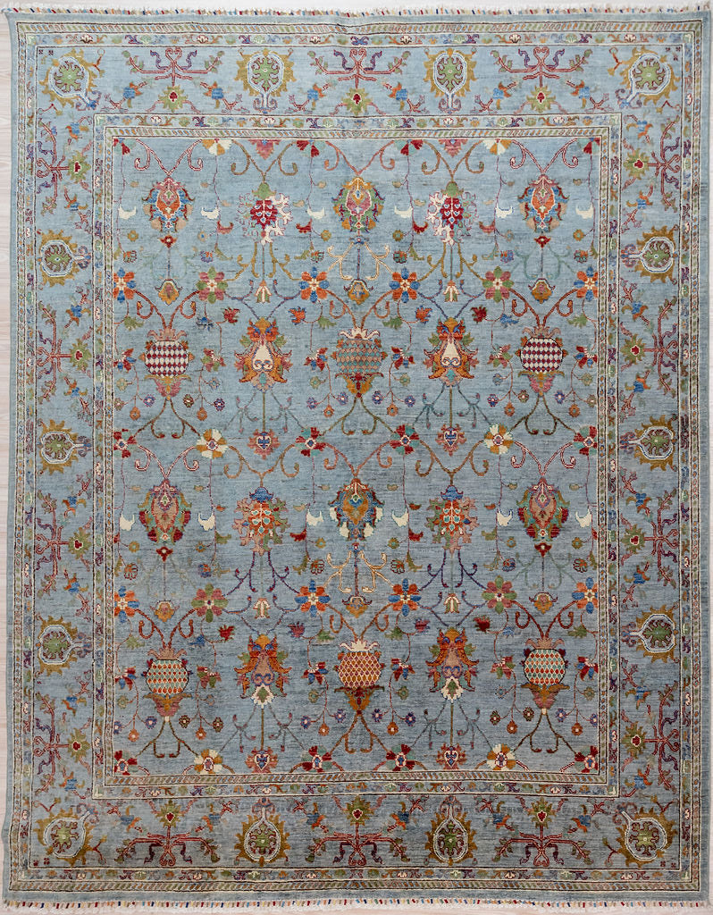 Hand knotted Ice Blue Afghan Sultani Chobi Wool Rug 295cm x 248cm woven in Mazar, Northern Afghanistan by creative female artisans who are experts in natural dyes
A one of-a-kind romantic, oriental rug expressing the joy of a snowmelt Spring within a restrained contemporary paler colour palette
Featuring a cool ice blue background this rug is at home in any modern architectural setting or near water.

Ariana tassels woven on the top and bottom edges, by female artisans