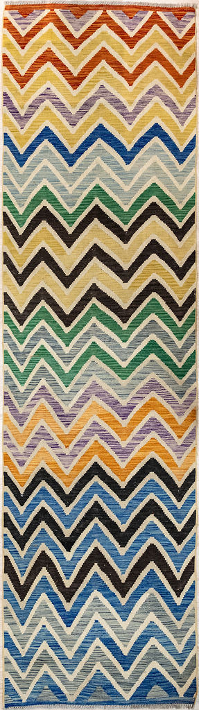 Authentic Hand Knotted Multicolour Afghan Boho Kilim Wool Runner 339cm x 81cm in a zigzag style. May blend with Missoni decor
Kilims are a flatweave runner used for over a millennium in Tribal areas of Central Asia and Anatolia. Historically used by nomads as floor covering, tent covering carried on horseback for its lightweight nature
Perfect for a summer runner, 