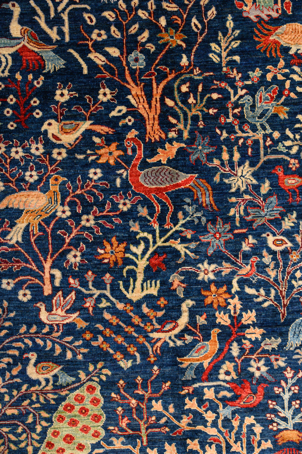 Authentic Handknotted Navy Pictorial Afghan Chobi Wool Rug 300cm x 247cm woven in Shebarghan, Afghanistan
A unique, one-of-a-kind botanical Pictorial design bringing a touch of both traditional and modern contemporary
Intense fNavy Blue background colour contrasts with images of rural abundance, flowering orchard trees, animals and birds including peacocks.
Vibrant and mesmerising colour palette
Ariana tassels woven on the top  bottom.