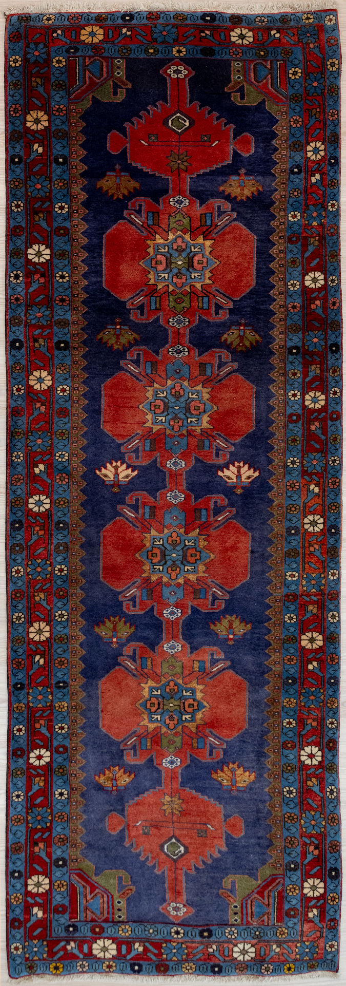 Guaranteed Navy Red Vintage Persian Hamadan Wool Runner 290cm x 101cm woven in Central Asia.

Glowing orange to red hexagons parade down this striking runner. The rug is ever so slightly asymmetrical in detail which is a mark of a tribal one-off hand made piece. The practical natural indigo navy base is deep and dark. Did you know indigo is actually anti-microbial?
