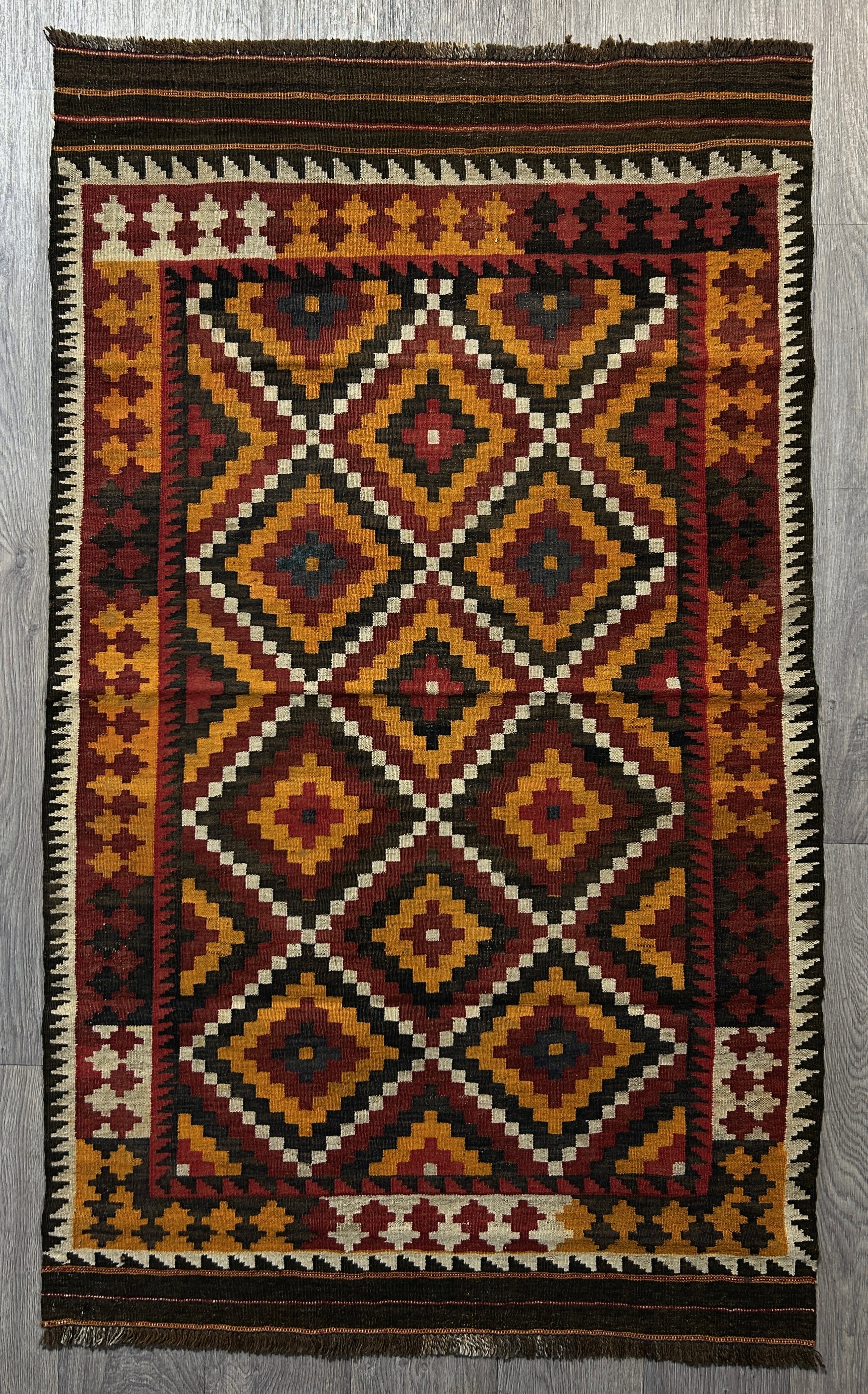 Authentic Handknotted Vintage Persian Kilim Wool Rug Woven in the 1960's 175cm x 104cm
Strong colours made with natural dyes such as madder root. Suits Boho, modern or MCM interiors. Lovely rug with rare finishing touch , a  striped border, on each end.
