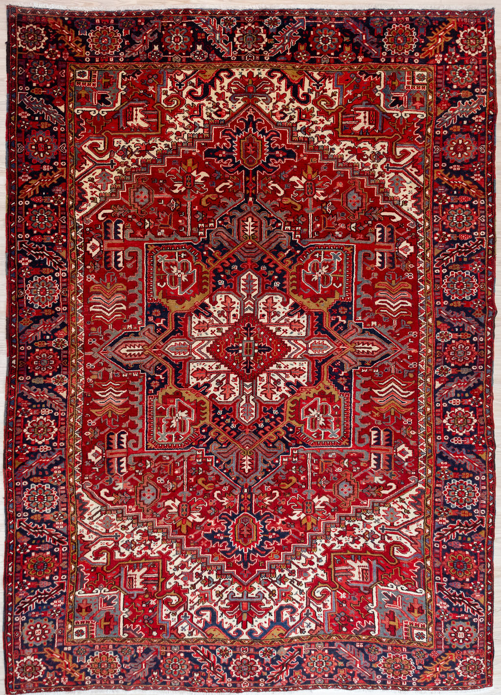 Authentic Hand Knotted Red Persian Heriz Wool Rug 350cm x 260cm &nbsp;Woven in the city of Heriz, in the northwest of Iran known for its unique architectural style villages
Woven circa 1970's, Heriz rugs are made from quality wool. Mountain sheep dine on plants high in copper making for extremely durable wool
Known for its larger than life bold geometric designs with centre medallion.
Beautiful combination of red, pink, indogo and tones of brown harmonise in this gracefully aged traditional rug.