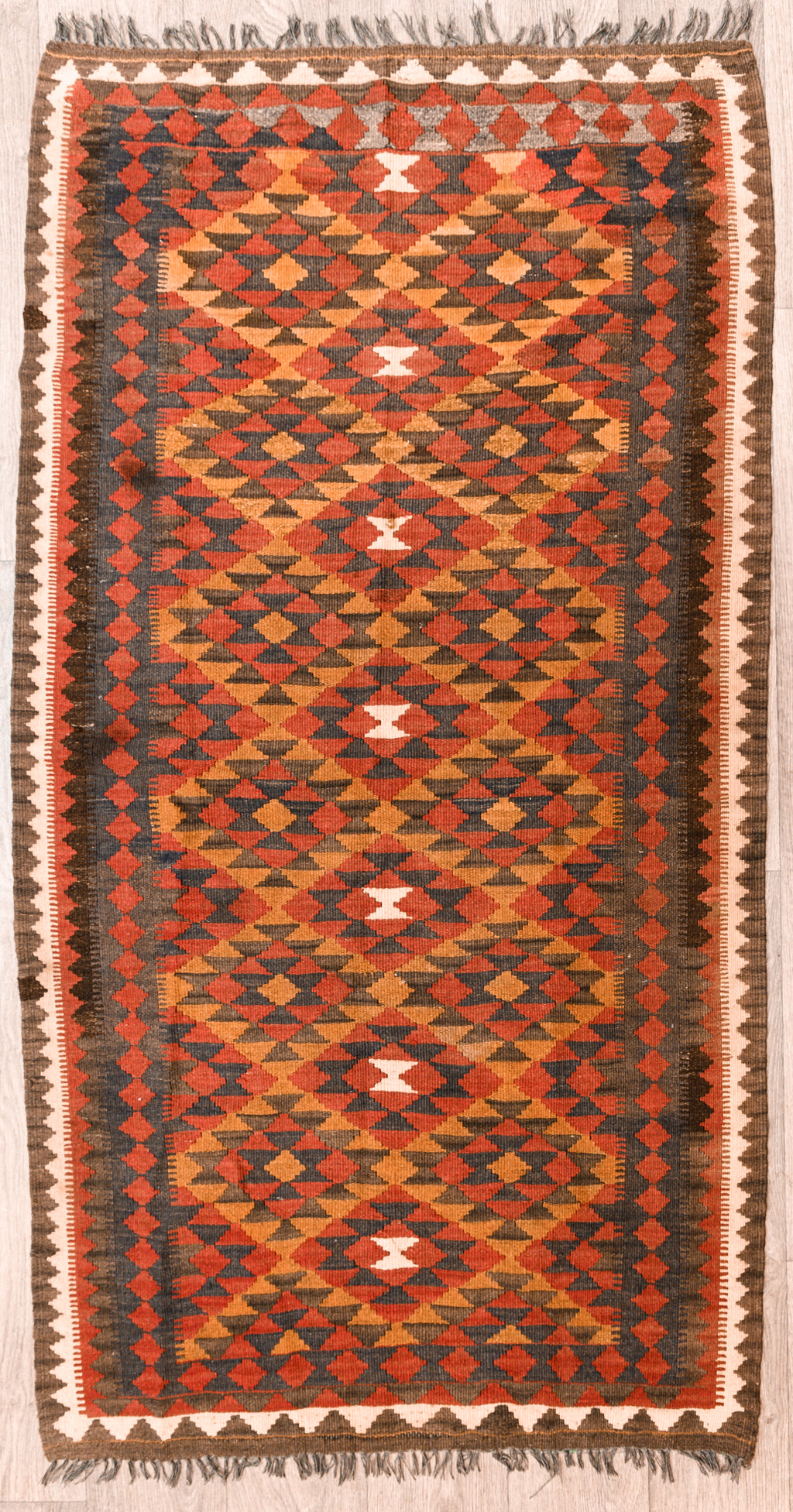 Authentic Handknotted Red Vintage Persian Kilim 193cm x 104cm Strong colours made with natural dyes such as madder root. Suits Boho, modern or MCM interiors. Affordable ethnic chic.
Lovely rug with central cream accents and an ornate border on both sides and ends
Durable and Wear Resistant Suitable for High Traffic Areas