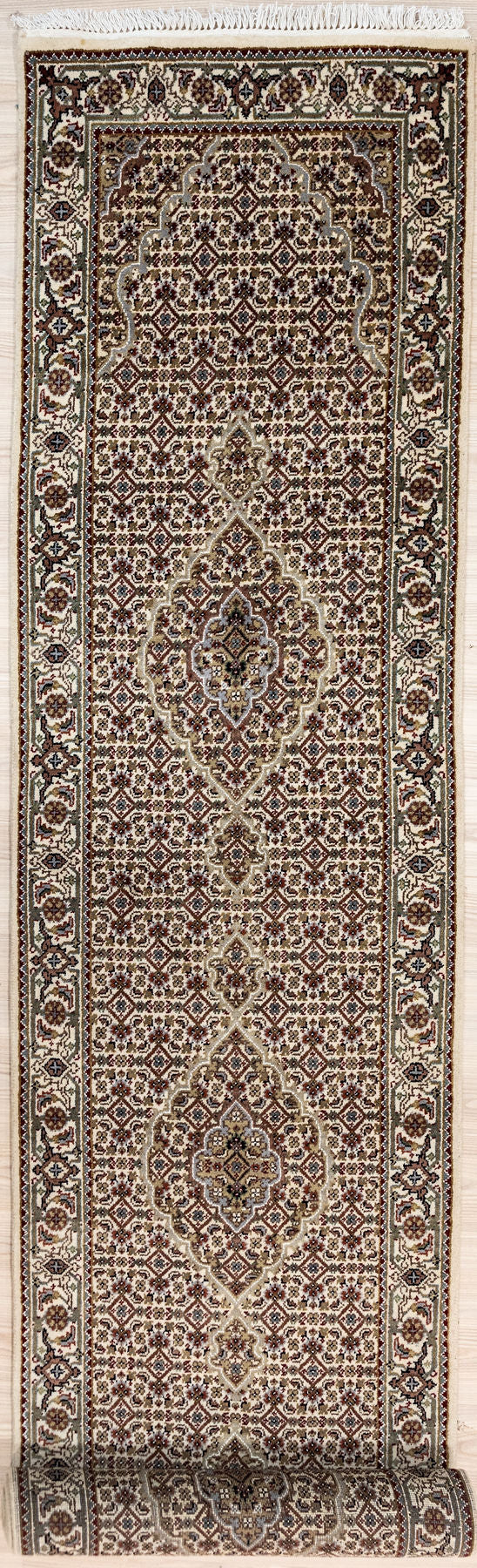 Finely Hand knotted Thick Pile Indo Tabriz Mahi (Fish) Design 386cm x 83cm warm, thick stylish and practical and long lasting. Wear Resistant Suitable for High Traffic Areas
An interesting rarely seen variant on the Mahi theme with extra intricate patterns in the main field. Woven in a restricted colour scheme of greys and browns on cream.
A forgiving pattern for normal hallway foot traffic debris but still light and bright.