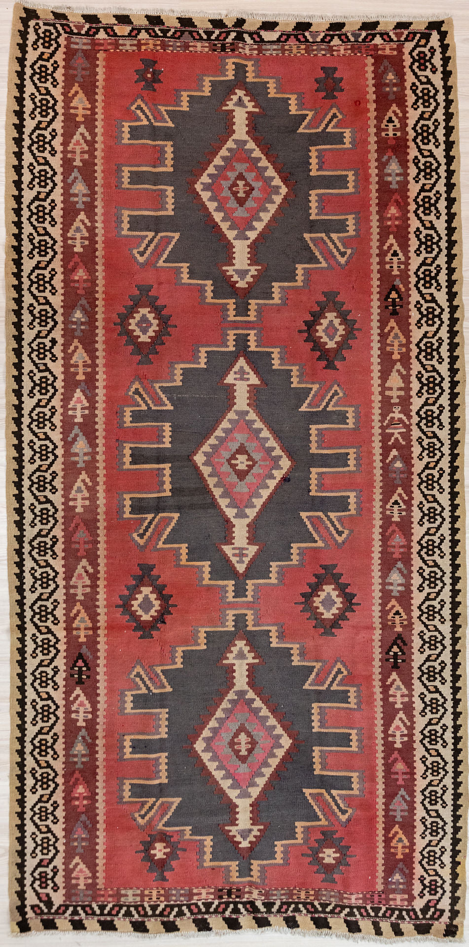 Authentic Handknotted Vintage c1970's Turkish Wool Kilim 300cm x 160cm
In popular midcentury colours of dusty pink, browns, orange and deep blue this rug is a good size for a galley kitchen or sunroom
The colour tones have aged gracefully over the decades and the wool softens
Kilims are a light flatweave reversible rug used for over a millennium by the nomadic tribes of Central Asia&nbsp;

Durable and Wear Resistant Suitable for High Traffic Areas