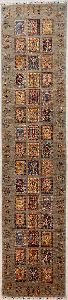 Guaranteed Handknotted Taupe Pictorial Afghan Chobi Wool Runner 370cm x 85cm
Woven in Shebarghan Northern Afghanistan, by artisan families living the original rural lifestyle. This exciting runner depicts different beds in a oriental walled garden filled with flowering trees, vegetables and plants. The flowers and trees on the borders represent the open fields and pastures.
This one-off durable, wear resistant  runner protects as well as reducing noise and it is a practical colour to forgive any foot traffi