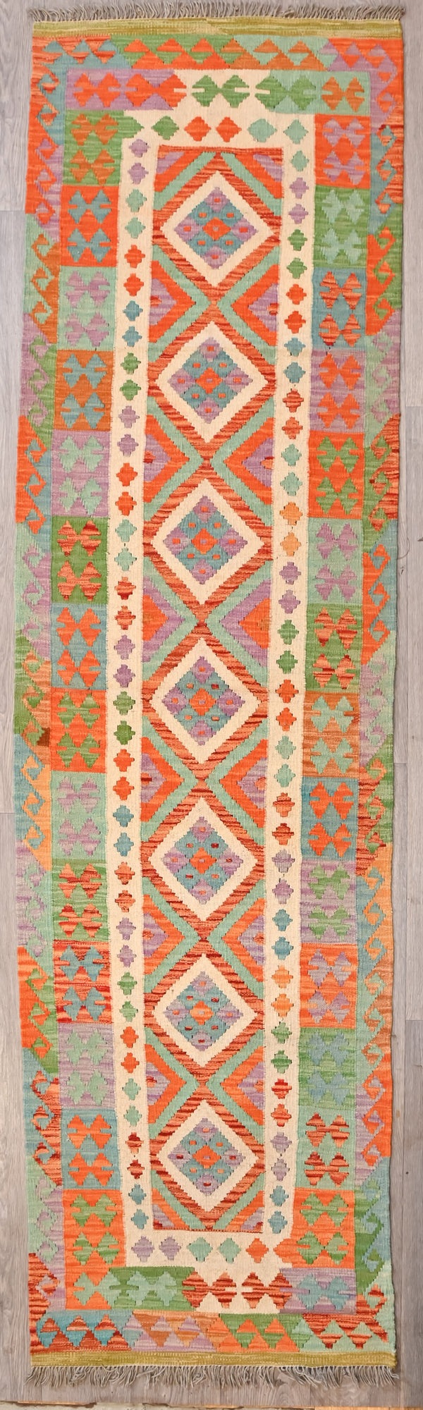 Authentic Hand knotted Multicolour Boho Kilim Wool Runner 300cm x 81cm
Central cream train tracks and medallions guide your eyes in

Modern lighter tones and marled variegated colour blocks makes this runner suitabe for city, rural ,coastal or boho vibe.
Durable and Wear Resistant Suitable for High Traffic Areas
All Colours in This Piece Originate from Natural Vegetable Dyes